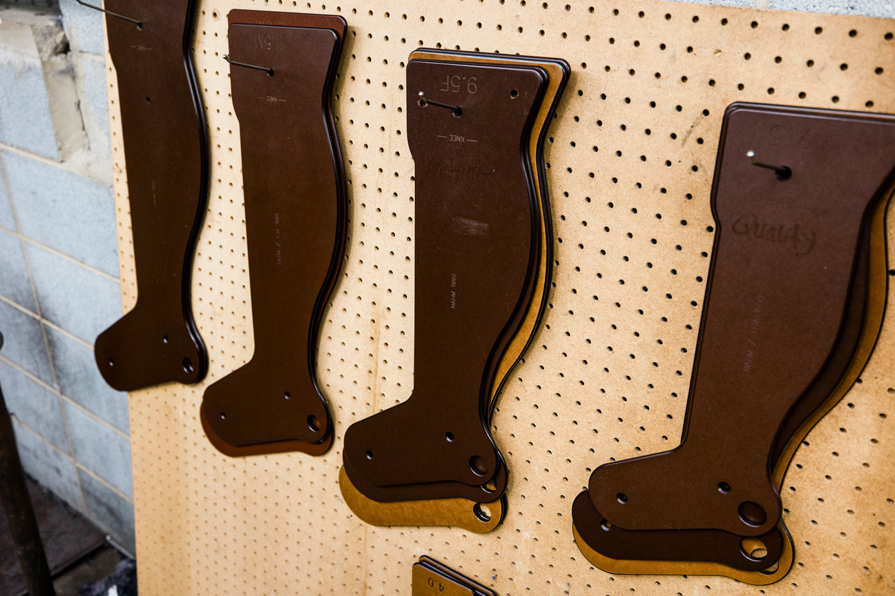 wooden sock mannequins hanging up in a factory