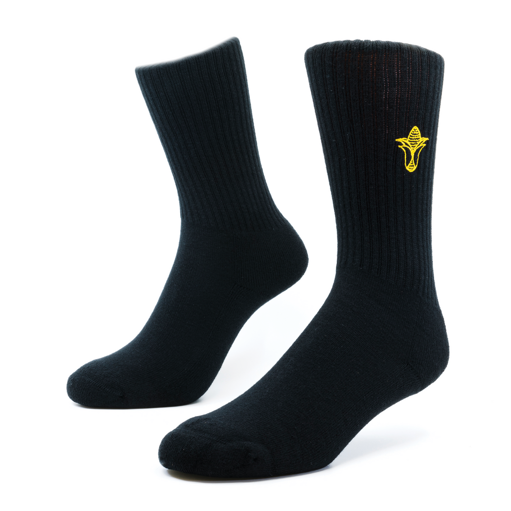 a Pair of black socks with a yellow icon of corn embroidered