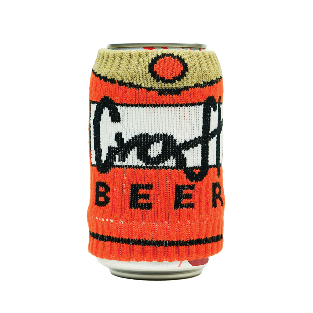 A can covered with a knitted drink sleeve that says Craft Beer with bright orange colors